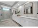 Luxurious bathroom with dual sinks, white cabinetry, and a modern tiled shower at 1957 W Lonesome Trl, Phoenix, AZ 85085