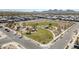 Scenic aerial view of a neighborhood park with green spaces, walking paths, playground, and desert landscape at 1957 W Lonesome Trl, Phoenix, AZ 85085