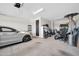 Well-lit garage with a silver car parked inside and various items stored, providing ample storage and parking space at 1957 W Lonesome Trl, Phoenix, AZ 85085