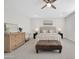 Bright main bedroom featuring a ceiling fan, neutral colors, and a padded ottoman at 1957 W Lonesome Trl, Phoenix, AZ 85085