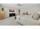 Bright main bedroom featuring a ceiling fan, console with TV, and an ensuite bathroom at 1957 W Lonesome Trl, Phoenix, AZ 85085