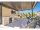Outdoor kitchen boasts a beverage center, built-in grill, and covered patio with comfortable wicker furniture and a TV at 1957 W Lonesome Trl, Phoenix, AZ 85085