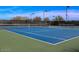 Well-maintained tennis courts surrounded by fencing and trees, perfect for recreational play in a community setting at 1957 W Lonesome Trl, Phoenix, AZ 85085