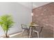 Cozy dining area featuring a glass table, brick accent wall, and modern pendant lighting at 207 W Clarendon Ave # B22, Phoenix, AZ 85013