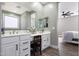 Bright bathroom features a double vanity with white cabinets and granite counters, plus wood-look tile flooring at 22805 W Hopi St, Buckeye, AZ 85326