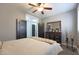 This bedroom features a ceiling fan and dark wood accent furniture and doors at 22805 W Hopi St, Buckeye, AZ 85326