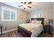 Comfortable bedroom with wood-look floors, a ceiling fan, and soft lighting at 22805 W Hopi St, Buckeye, AZ 85326