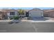 Charming single-story home with a well-manicured lawn, desert landscaping, and a two-car garage, all in a warm and inviting color palette at 22805 W Hopi St, Buckeye, AZ 85326