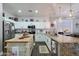 Well-lit kitchen with white cabinets, an island, and granite countertops at 22805 W Hopi St, Buckeye, AZ 85326