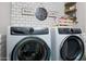 Laundry room with front-loading washer and dryer under signs and shelves at 22805 W Hopi St, Buckeye, AZ 85326