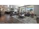 Bright living room featuring hardwood floors, dual sofas, a stylish rug, and large windows offering backyard views at 22805 W Hopi St, Buckeye, AZ 85326