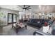 Open-concept living room featuring dark wood floors, and a large black leather sofa at 22805 W Hopi St, Buckeye, AZ 85326