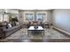 Bright living room featuring hardwood floors, dual sofas, a stylish rug, and large windows offering backyard views at 22805 W Hopi St, Buckeye, AZ 85326