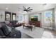 Cozy living room with dark wood floors, a sectional sofa, a large ceiling fan, and a media center with a flat-screen TV at 22805 W Hopi St, Buckeye, AZ 85326