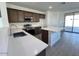 Modern kitchen with stainless steel appliances, quartz countertops, and a center island overlooking the backyard at 23252 W Miami St, Buckeye, AZ 85326