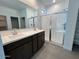 En Suite bathroom featuring a double sink vanity, a large walk-in glass shower, and luxury vinyl plank flooring at 23252 W Miami St, Buckeye, AZ 85326