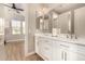 Bright bathroom boasts a double vanity, a large mirror, and wood-look floors at 3005 E Valencia Dr, Phoenix, AZ 85042