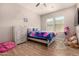 Cozy bedroom features wood-look floors, ceiling fan, natural light, and neutral paint at 3005 E Valencia Dr, Phoenix, AZ 85042