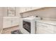 Bright laundry room with white cabinets, countertops, and modern washer and dryer at 3005 E Valencia Dr, Phoenix, AZ 85042