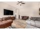 Living room featuring leather sofas, a modern media console, and a large screen TV at 3005 E Valencia Dr, Phoenix, AZ 85042