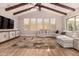 Open living room featuring a large sectional, wood-beamed ceiling, and modern furnishings at 3005 E Valencia Dr, Phoenix, AZ 85042