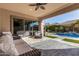 Covered patio with comfortable seating, ceiling fan, and an open view of the pool and backyard oasis at 3005 E Valencia Dr, Phoenix, AZ 85042