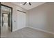 Bedroom featuring gray tile floors, neutral colored walls, modern ceiling fan, and sliding closet doors at 3145 S 363Rd Ave, Tonopah, AZ 85354