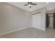 Bedroom featuring gray tile floors, neutral colored walls, modern ceiling fan, and sliding closet doors at 3145 S 363Rd Ave, Tonopah, AZ 85354