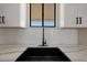 A modern kitchen with a black sink and faucet complementing white subway tiles and light countertops at 3145 S 363Rd Ave, Tonopah, AZ 85354