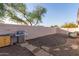 Backyard with BBQ grill, neutral gravel landscaping, and lush tree providing shade at 3403 E Kristal Way, Phoenix, AZ 85050