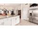 Spacious kitchen with an island, stainless refrigerator, and sightlines to the living area at 3403 E Kristal Way, Phoenix, AZ 85050