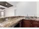 Wet bar with granite countertops and wood cabinets is the perfect entertaining space at 36923 N 31St Ave, Phoenix, AZ 85086