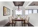Bright dining room with modern chandelier, sleek table setting, and a large window with stunning desert views at 36923 N 31St Ave, Phoenix, AZ 85086