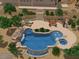 A backyard swimming pool featuring a hot tub, waterfall, lounge chairs, and ample patio space surrounded by lush greenery at 36923 N 31St Ave, Phoenix, AZ 85086