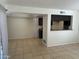Open-concept living room featuring tiled flooring and a breakfast bar overlooking the kitchen area at 4424 E Pueblo Ave, Phoenix, AZ 85040