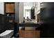 Modern bathroom with stylish black and gray tile, sleek fixtures, and a well-lit mirror at 4725 N 56Th St, Phoenix, AZ 85018