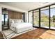 Modern bedroom features hardwood floors, a luxury rug, and a large picture window boasting beautiful outdoor views at 4725 N 56Th St, Phoenix, AZ 85018