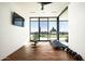 Bright exercise room with hardwood floors, a TV, a weight bench, a treadmill, and sliding glass doors at 4725 N 56Th St, Phoenix, AZ 85018