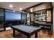 Well appointed game room features a modern pool table, stylish bar area, and doors leading to balcony with city views at 4725 N 56Th St, Phoenix, AZ 85018