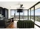 Modern living room with hardwood floors, a green velvet couch, and expansive windows showcasing breathtaking outdoor views at 4725 N 56Th St, Phoenix, AZ 85018