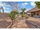 Backyard featuring desert landscaping, green shrubs, a rock river, and a covered patio at 5042 S Marigold Way, Gilbert, AZ 85298