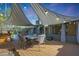 Backyard deck featuring a dining set, shade sails, BBQ, and string lights at 556 W Kiva Ave, Mesa, AZ 85210