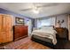 Comfortable bedroom with hardwood floors, a ceiling fan, and a well-lit window at 556 W Kiva Ave, Mesa, AZ 85210