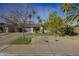 Charming single-story home with well-maintained landscaping, gravel yard, and a blue garage door at 556 W Kiva Ave, Mesa, AZ 85210