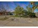 Charming single-story home featuring desert landscaping, mature trees, and a two-car garage at 556 W Kiva Ave, Mesa, AZ 85210