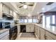 Well-lit kitchen features granite counters, neutral cabinets, black appliances, and a window over the sink at 556 W Kiva Ave, Mesa, AZ 85210