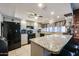 Bright kitchen with granite countertops, white cabinets, black appliances, and island with seating at 556 W Kiva Ave, Mesa, AZ 85210