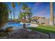 Private backyard featuring a sparkling pool, lush landscaping, and brick-paved patio area at 556 W Kiva Ave, Mesa, AZ 85210
