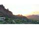 An aerial view of a luxury home at sunset nestled near a mountain range at 5648 N Superstition Ln # 5, Paradise Valley, AZ 85253