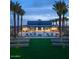 Luxurious community pool with palm trees, lounge chairs, and a clubhouse in the background at 5741 E Star Valley St, Mesa, AZ 85215